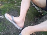 Twink wearing gray flip flops short shorts walks relaxes wanks his cock near water in public outdoor