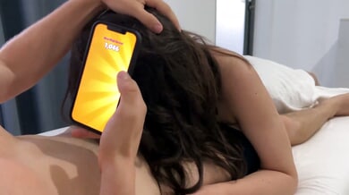 Curvy brunette gives her boyfriend a blowjob while he plays games in bed