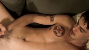 ”Deviant young man with tattoos strokes his big unshaved prick”