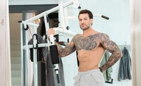 Handsome man with tattoos working out with a hunk