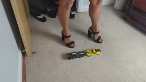 Nikkichick crushes a Boss 302 Mustang and a Pontiac Camaro in big block heels with painted toe nails toy car crush high left view
