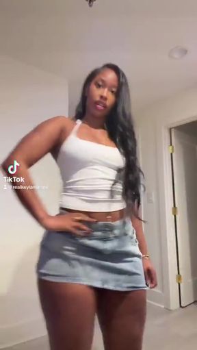 Curvy black woman in crop top and denim skirt