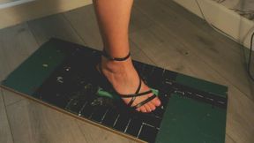 Giantess goddess WinnieLouxo Crushes a Chevrolet Malibu in black block heels with painted toenails low right view with box crush