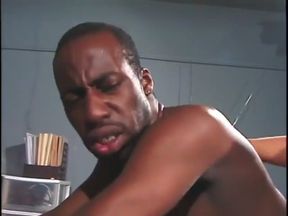 Manly stud sits back on a chair and lets his black lover blow his dick