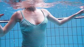 Playful redhead chick Anetta swims naked in the pool