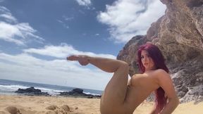 Gymnast stretching on the nudist beach