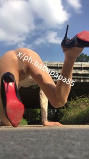 sissy in red bottom high heels and white hollow top exposes herself and pees under highway bridge