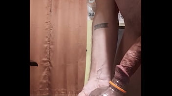 Johnny Hung pissing in an empty bottle of red juice