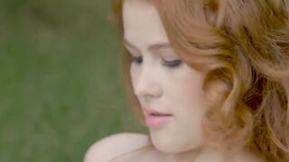 Young redhead sensually teasing in nature