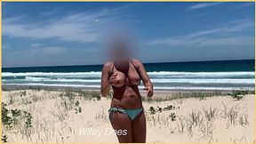 Beachside babe flaunts assets sans bikini top, jugs bouncing in wind