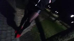 crossdresser walking in public park in heels