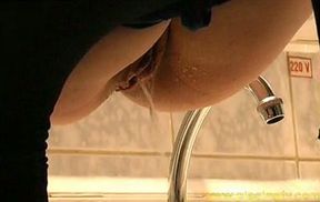 Russian redhead lady sits on the bathroom shelf and pees in the sink