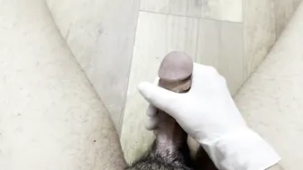 Solo twink gives his big cock a slow gloved handjob until he cums