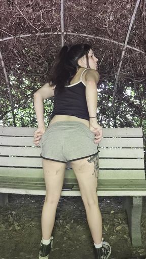 Slim exhibitionist bends over in a greenhouse and waits for some