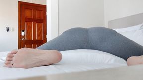 Stretching on the bed in yoga pants