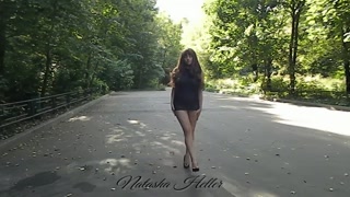 A young beautiful exhibitionist wife in a transparent dress shows her pussy and ass in a public Park