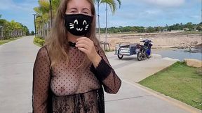 A girl walks in a transparent dress in the park