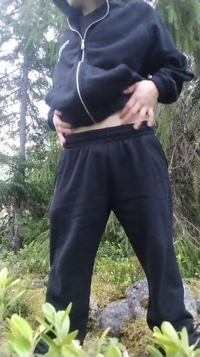 Man in black hoodie and sweatpants standing outdoors