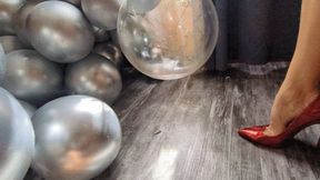 Katherine bursting balloons under her sexy red stilettos