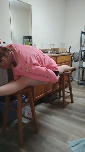 Splits on two stools in orange dress