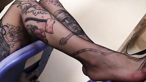 ”Sotto al tavolo, I piedi in collant della segretaria tatuata”