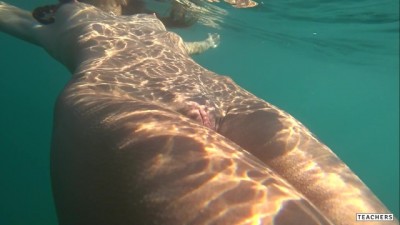 Nude model swims on a public beach