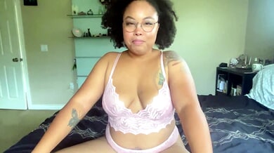 Curvy ebony woman in glasses gives firm jerk off commands from bed