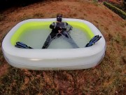 Rufus pawing off in wetsuit, fins and pool