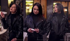 A voluptuous girl smoking in public, dressed in black, and enjoying a coffee