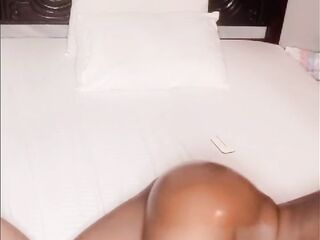 Afro woman rubbing and smacking oiled butt in daybed