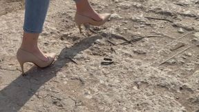 A girl in high-heeled shoes walks through the trash and tramples the trash