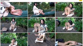 The classic beauty Yuan Bao wears a white cheongsam, smokes a cigarette, and puts her feet on the table in the park to leisurely show her beautiful feet