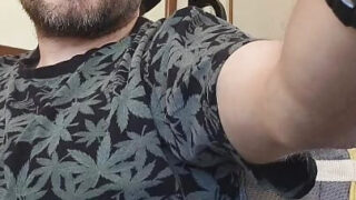 رجل ذو شعر كثيف يداعب قضيبه الضخم حتى يصل إلى ذروة النشوة الجنسية.