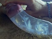 The guy cums in a condom with hot water with powerful volleys