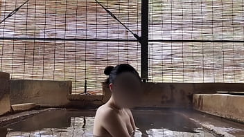 Japanese girl bathing in a mixed outdoor bath at a hot spring inn