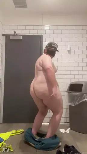 Chubby guy strips naked in bathroom.