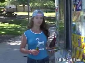 Little April rubs her pussy with a lollipop while fingering her tight pussy outdoors