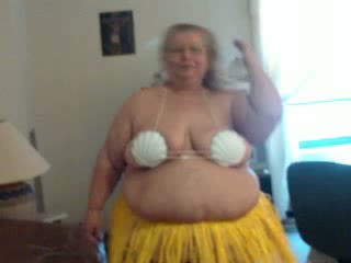 Obese grandma in glasses dances for me in Hawaiian skirt