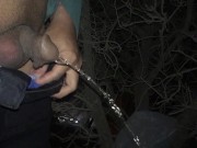 Pissing at a scary night in a public area when people are passing by and cars run along the road
