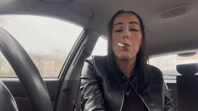 Smoking in car wearing leather gloves and jacket