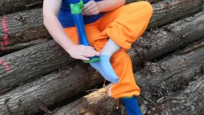 Sitting in rubberboots on woodpile
