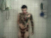 Homme bi et tattoué prend une longue douche chaude