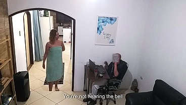 While the husband works, the wife in a towel greets the delivery man.