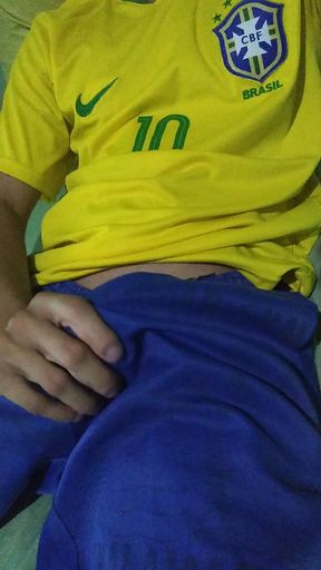 Young Brazilian masturbates big thick cock taking off his clothes wearing the Brazilian national team soccer uniform