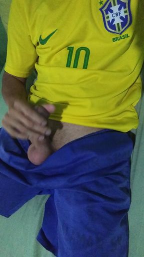 Young Brazilian masturbates big thick cock taking off his clothes wearing the Brazilian national team soccer uniform