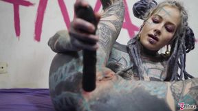 Fully inked blonde stretches her ass with black toy