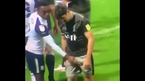 Pegando na rola do jogador no campo de futebol