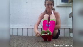 Tickling her feet outdoors in long knee socks with toothbrush