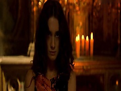 Paz Vega seen from behind in a campfire-lit cave as she