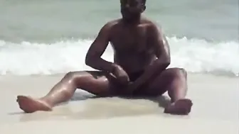 Black guy jerking his big cock at the beach